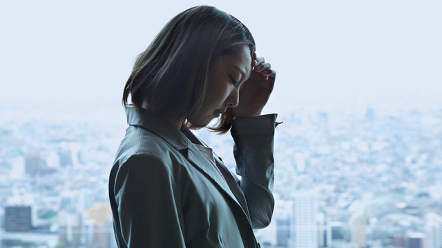 Depressed young woman,cityscape in background
