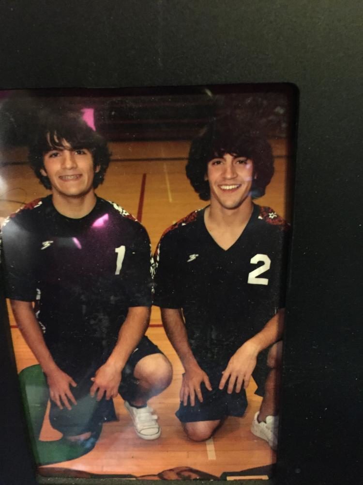 Mr.Shingler in high school, left, next to his twin brother, in their volleyball uniforms.