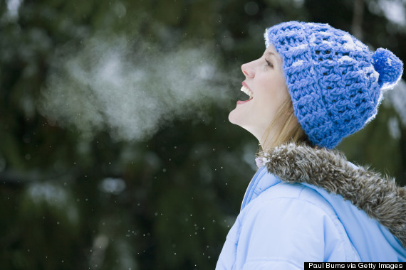 Young woman wearing winter hat, laughing, outdoors