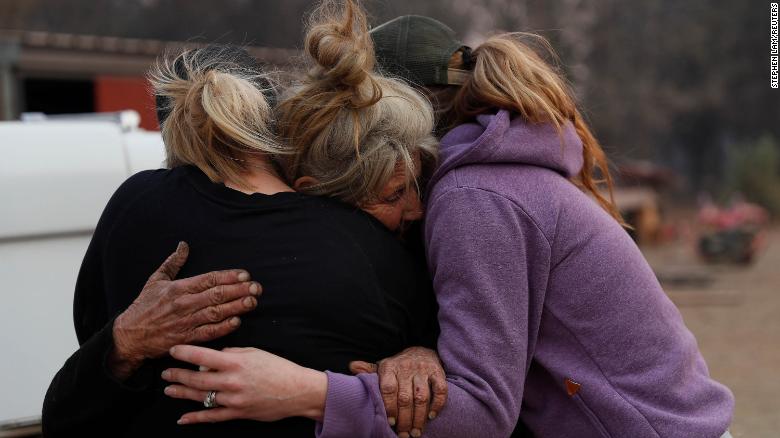 Cathy Fallon (C) who stayed behind to tend to her horses during the Camp Fire, embraces Shawna De Long (L) and April Smith who brought supplies for the horses in Paradise, California, U.S. November 11, 2018. REUTERS/Stephen Lam