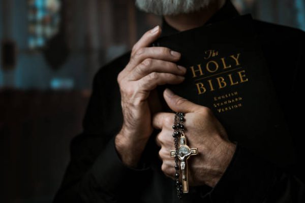 Priest holding metal cross